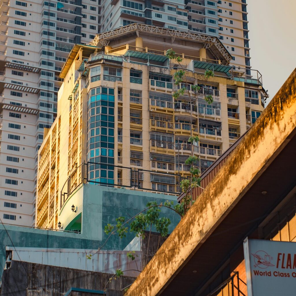 Sunset light casts a warm glow on an urban high-rise building, enhancing its architectural features.